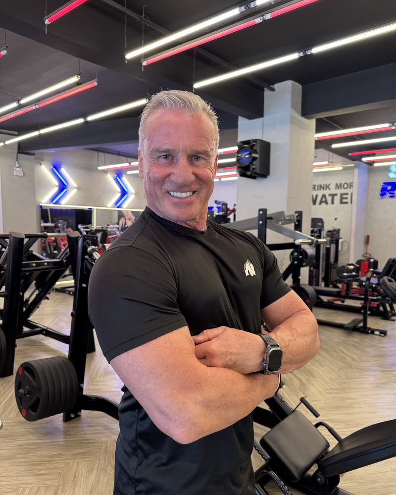 Michael Seitel mit verschränkten Armen im Fitnessstudio, lächelnd