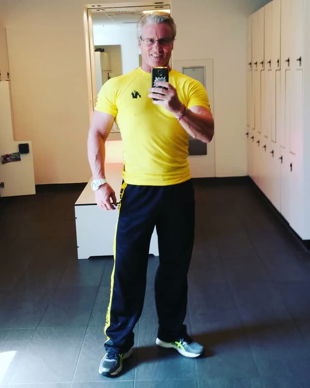 Michael Seitel in gelbem Shirt im Umkleidebereich eines Fitnessstudios